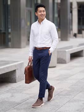 Slim-fit navy chinos paired with a crisp white button-down shirt and a matching brown leather belt for a classic office look.