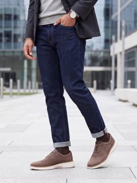 Dark indigo selvedge denim, a light grey merino wool sweater, and a tailored charcoal blazer for a refined date night ensemble.