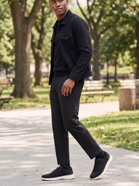 Style with black tailored trousers and a high-quality black t-shirt under a denim jacket for a contemporary, monochromatic streetwear-inspired ensemble.