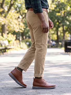 Khaki corduroy pants combined with a deep forest green plaid flannel shirt and a brown leather belt to match the cognac leather of the boots.