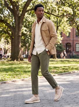 Mens Riginalgrand Remastered Wingtip Oxfords – Olive green tapered trousers rolled at the cuff, styled with a cream-colored linen shirt and a tan field jacket for an earthy, refined weekend aesthetic.