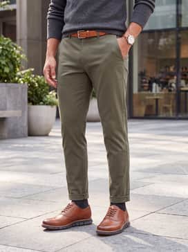 Mens Zergrand Remastered Wingtip Oxfords – Tapered olive chinos paired with a light grey cashmere crewneck sweater and a matching tan leather belt.
