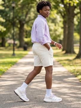 Off-white chino shorts worn with a crisp lilac linen button-down shirt and simple silver accessories for a clean, casual summer vibe.