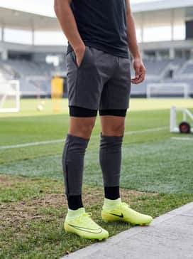A sleek training ensemble consisting of a charcoal grey tech-fleece quarter-zip pullover and slim-fit black training pants with ankle zippers.