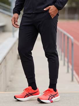 Metaspeed Edge Tokyo – Athleisure cool: Tapered black technical joggers with a matching zip-up windbreaker and a breathable mesh baseball cap for a cohesive, athletic post-run look.