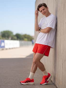 Metaspeed Edge Tokyo – Summer training: Vibrant red mesh running shorts to match the shoe's upper, paired with a white oversized graphic performance tee and reflective accessories for high visibility.