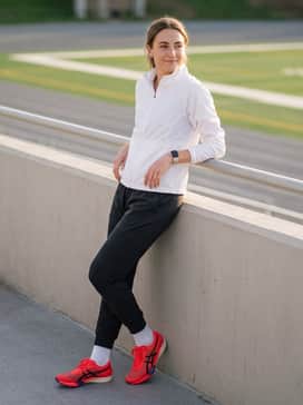 Pre-race warm-up attire featuring a breathable moisture-wicking zip-up windbreaker in white and tapered athletic joggers that allow for quick removal.