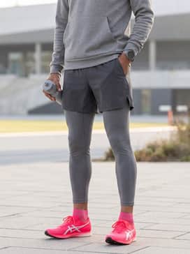 High-compression seamless long-sleeve performance top in heather grey paired with aerodynamic running tights in a sleek matte finish for chilly morning track sessions.