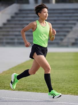 Elite Race Ready: Pair with ultra-lightweight black split running shorts, a matching neon green singlet, and high-performance compression socks for a professional track or road racing look.