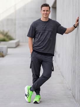 Urban Techwear: Match with black utility cargo pants featuring strap details and a dark charcoal oversized graphic tee to lean into the shoe's futuristic silhouette and bold color.