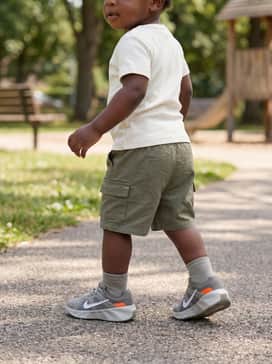 Style with olive green cargo shorts and a simple white ribbed tee for a rugged yet comfortable play-ready ensemble.