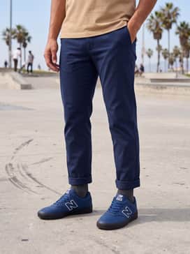 Tan chino shorts and a light grey polo shirt, accessorized with a navy blue baseball cap for a preppy yet relaxed summer aesthetic.
