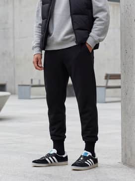 Newcastle Spzl Fc Shoes – Tapered black joggers combined with a heather grey oversized hoodie and a black quilted puffer vest for a clean athleisure aesthetic.
