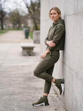 A coordinated athleisure set comprising matching olive green sweatpants and a cropped hoodie for a cohesive, monochromatic appearance.