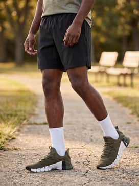 A summer-ready athletic vibe with black performance shorts, a breathable grey mesh jersey, and high-quality white crew socks pulled mid-calf.