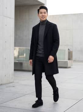 Nizzastar Lo – A pair of tapered black trousers paired with a charcoal grey cashmere turtleneck and a long wool overcoat for a sophisticated monochromatic look.