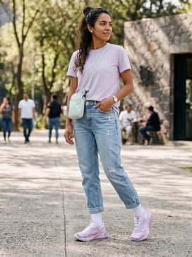 Light-wash distressed boyfriend jeans cuffed at the ankle, an oversized graphic t-shirt in white or soft blue, and a pale pink bucket hat for a relaxed, urban vibe.