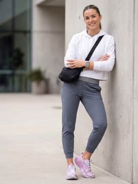 Slate grey tapered joggers, a cropped white hoodie, and a sleek nylon crossbody bag to keep the focus on the vibrant shoes while running errands.
