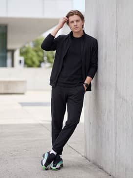 Nova Infinity Shoes – All-black slim-fit tracksuit for a high-contrast look that allows the multi-colored sneaker to serve as the primary statement piece.