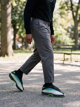 Nova Infinity Shoes – Cropped charcoal trousers with a black turtleneck and a minimalist silver chain for a sophisticated take on modern streetwear.