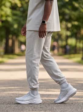 A modern monochrome streetwear vibe using oversized light grey sweatpants, a matching boxy-fit heavyweight tee, and a silver smartwatch to complement the shoe's tech-forward aesthetic.