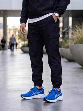 Novablast 5 – An urban streetwear ensemble consisting of tapered black cargo joggers, a structured oversized white tee, and a minimalist black windbreaker to create a sleek, high-contrast silhouette.
