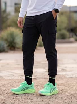 Novablast 5 Ekiden – Urban streetwear style with tapered black cargo joggers, a white oversized graphic hoodie, and a black nylon bomber jacket.