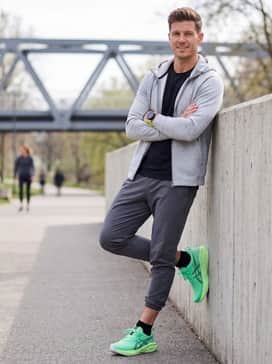 Novablast 5 Ekiden – A clean athleisure look using heather grey tech-fleece sweatpants, a fitted black long-sleeve base layer, and a neon-accented sports watch.