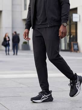 A refined streetwear style using slim-fit black denim, an oversized white graphic t-shirt, and a matte black bomber jacket for a sharp, monochrome finish.