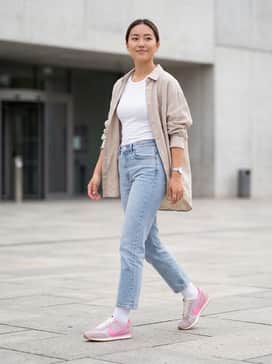 Pacific – Light-wash cropped straight-leg jeans, a fitted white ribbed tank top, and an unbuttoned oversized linen shirt in a neutral sand tone.