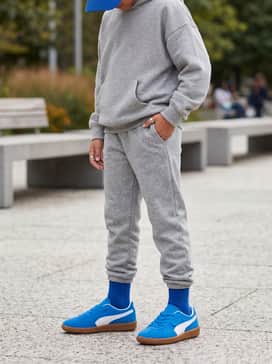 Heather gray joggers combined with a matching oversized hoodie and a cobalt blue baseball cap to lean into a cozy, coordinated athletic aesthetic.