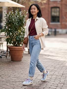 High-waisted light wash straight-leg jeans paired with a tucked-in burgundy baby tee and an oversized cream-colored corduroy shirt worn open as a light jacket.