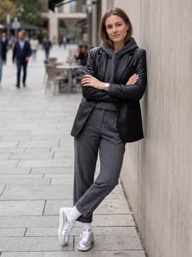 Palermo Chrome – Relaxed-fit grey tailored trousers and a cropped charcoal grey hoodie under a sleek black leather blazer for a sophisticated, high-low urban ensemble.