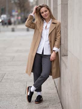 Palermo Leather – Relaxed-fit charcoal chinos and a crisp white button-down shirt left slightly unbuttoned, finished with a tan trench coat for a sophisticated urban look.