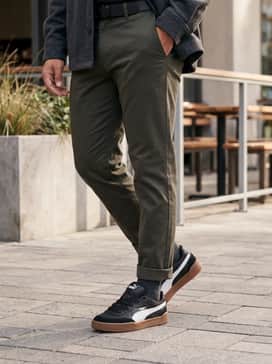 Tapered olive cargo pants paired with a black crewneck sweatshirt and a khaki utility vest for a modern streetwear vibe.