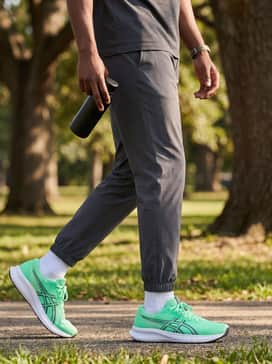Patriot 14 – Olive green cargo pants paired with an oversized black graphic tee and a silver chain necklace, creating a modern streetwear aesthetic that balances the vibrant shoe color.
