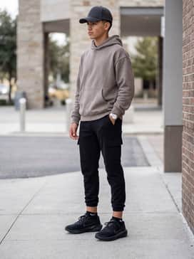 Pegasus 41 – A casual streetwear ensemble with tapered black joggers, an oversized neutral-toned hoodie, and a structured baseball cap for a relaxed vibe.