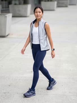 Pegasus Premium Se – High-performance compression leggings in deep navy paired with a silver reflective running gilet and a moisture-wicking white racerback tank.