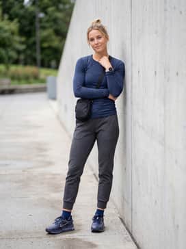 Pegasus Premium Se – Tapered tech-fleece joggers in charcoal grey, a fitted long-sleeve base layer, and a sleek crossbody bag for an urban utility look.