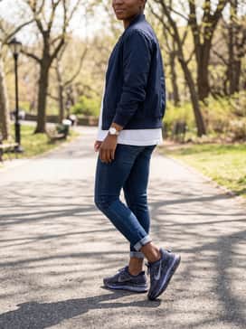 Pegasus Premium Se – Cuffed dark-wash skinny jeans, a crisp white oversized tee, and a navy nylon bomber jacket for a sporty-casual weekend ensemble.