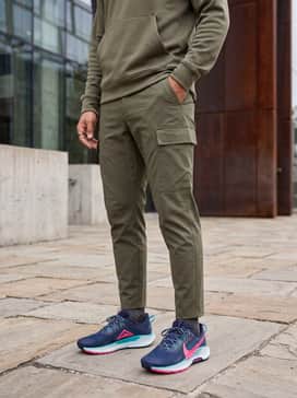 Pegasus Trail 5 – A streetwear-inspired outfit with olive green ripstop cargo pants, a black oversized hoodie, and a matching teal beanie to highlight the shoe's accents.
