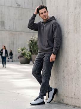 Distressed black denim, an oversized charcoal grey hoodie, and a matte black sports watch to play up the shoe's rugged yet refined vibe.