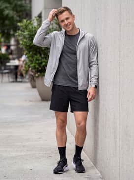 Performance-ready charcoal running shorts, a moisture-wicking black compression shirt, and a sleek silver-grey windbreaker.