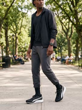 Pounce Lite – Tapered dark indigo jeans styled with a charcoal grey polo shirt and a minimalist black bomber jacket for a sharp evening out.