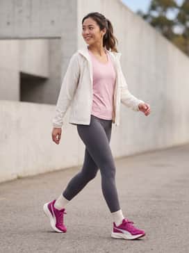 Pounce Lite Womens Shoes – High-performance athletic look with black compression leggings, a moisture-wicking charcoal grey racerback tank, and a lightweight white running jacket.