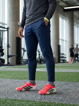 Predator Elite Artificial Ground Soccer Cleats – Dynamic Training Look: Combine the boots with a grey quarter-zip technical training top and tapered navy blue track pants. Incorporate a neon yellow headband or wristband to subtly echo the shoe's accent colors for a professional, coordinated training vibe.