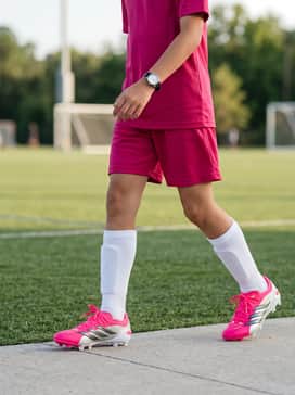 A matching team-colored jersey and moisture-wicking athletic shorts, paired with high-performance white soccer socks that allow the pink cleats to pop.