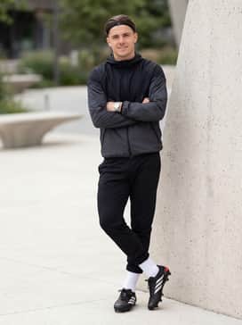 A professional warm-up look pairing a lightweight, breathable windbreaker with matching track pants and a moisture-wicking headband.