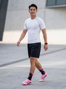 Matchday Kit: A pristine white compression jersey paired with black performance shorts and high-performance pink-accented football socks for a classic pitch look.