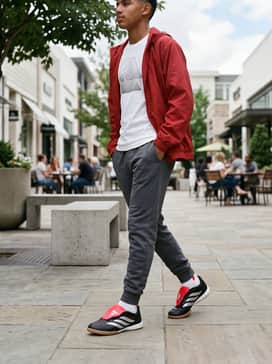 Predator League Foldover Tongue Indoor Soccer Shoes Kids – Casual school attire consisting of tapered grey joggers, a white graphic t-shirt, and a sporty red windbreaker.